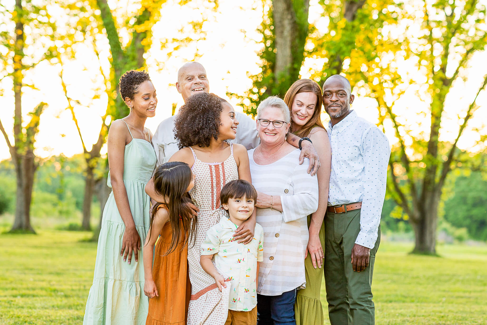extended mixed-race family laughing with each other during a birmingham family session