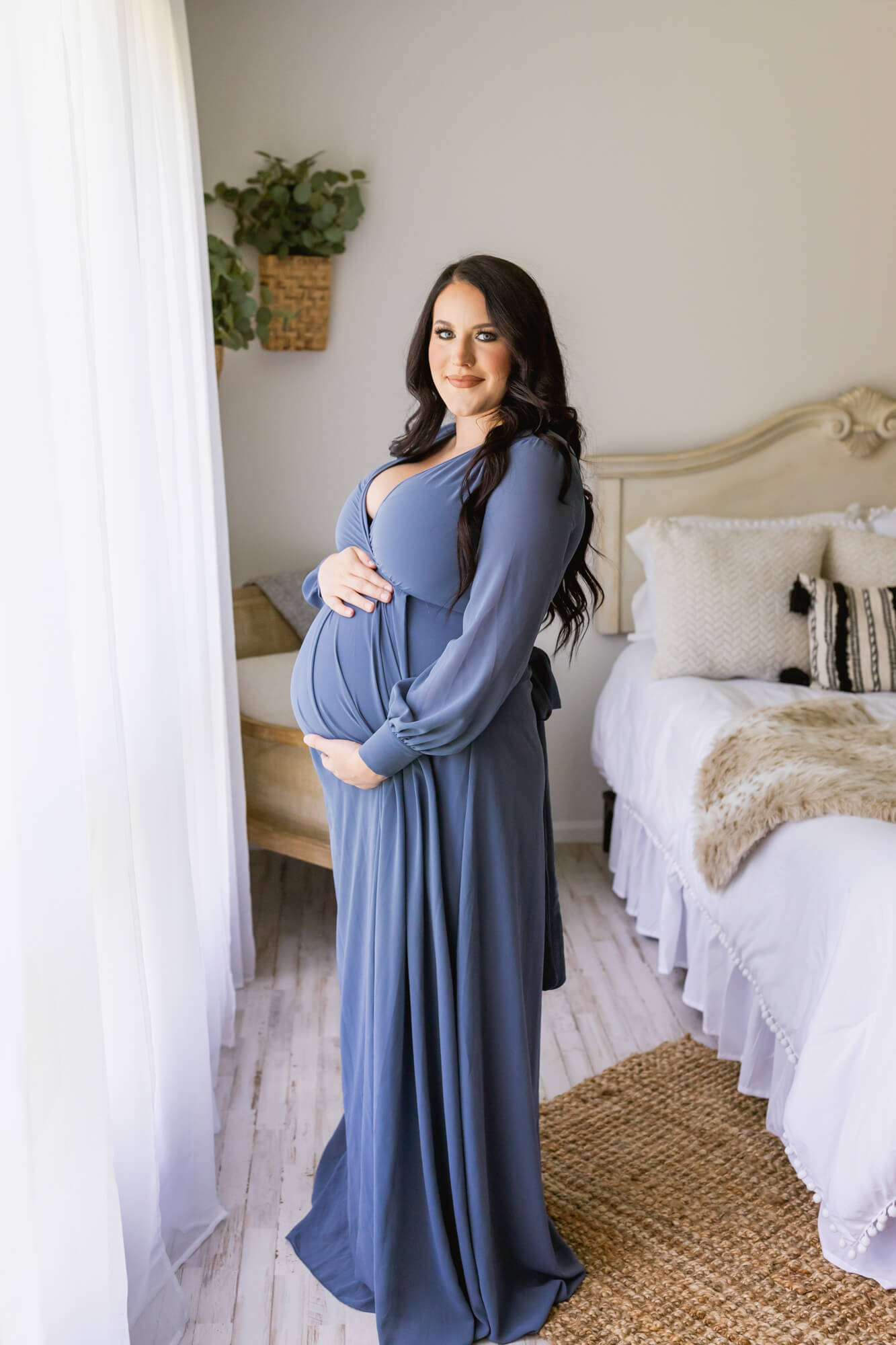 pregnant woman in blue long sleeve gown holding her bump