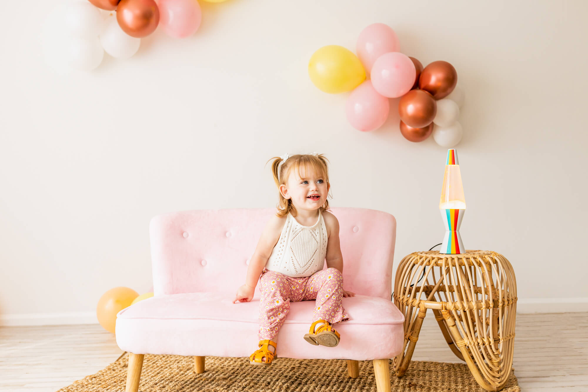 little girl in white shirt and pink pants sitting on a pink couch during her pink themed birthday from party planner birmingham al