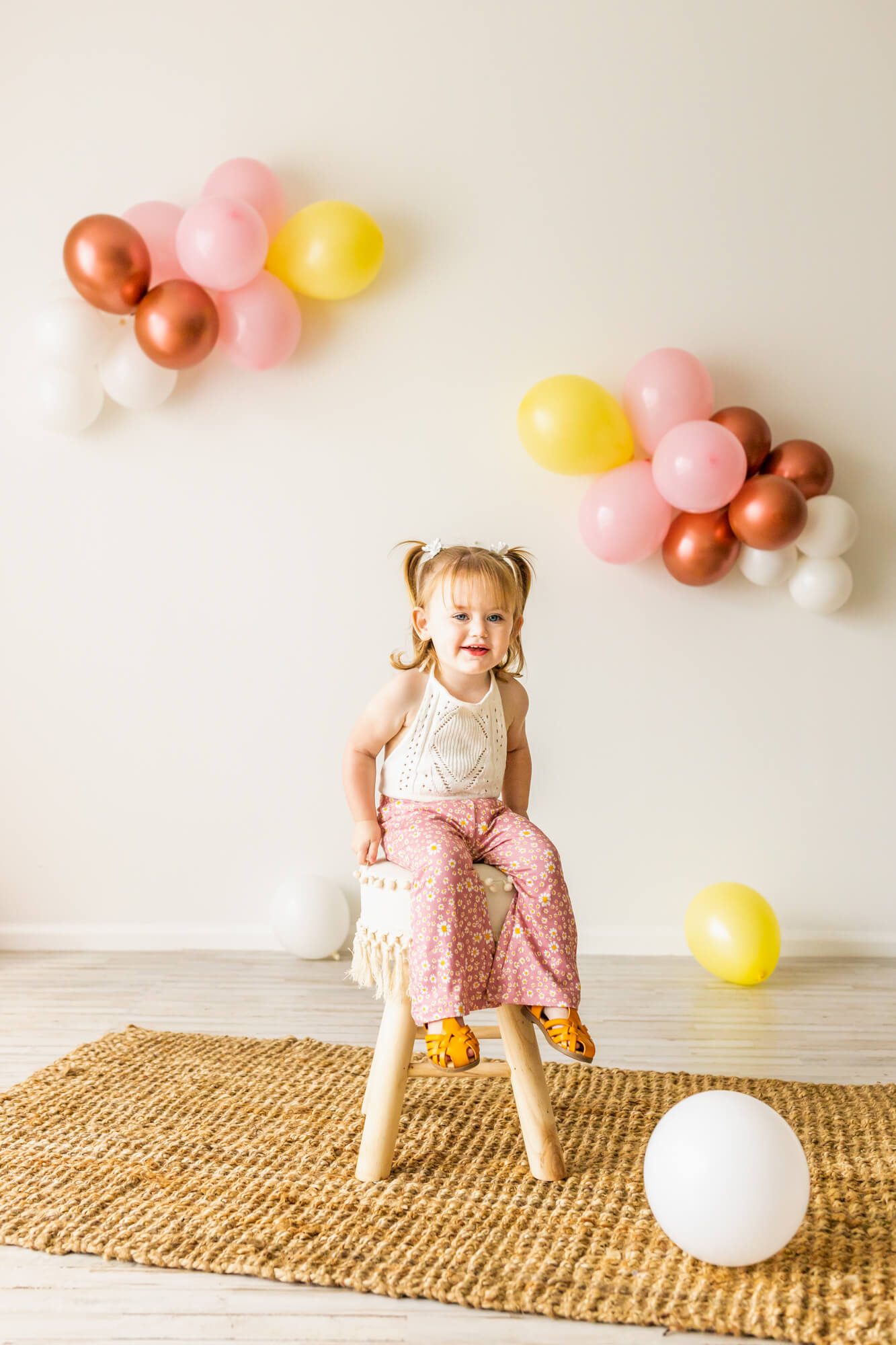 little girl in a white shirt, pink pants, and pigtails laughing at her birthday party by party planner birmingham al