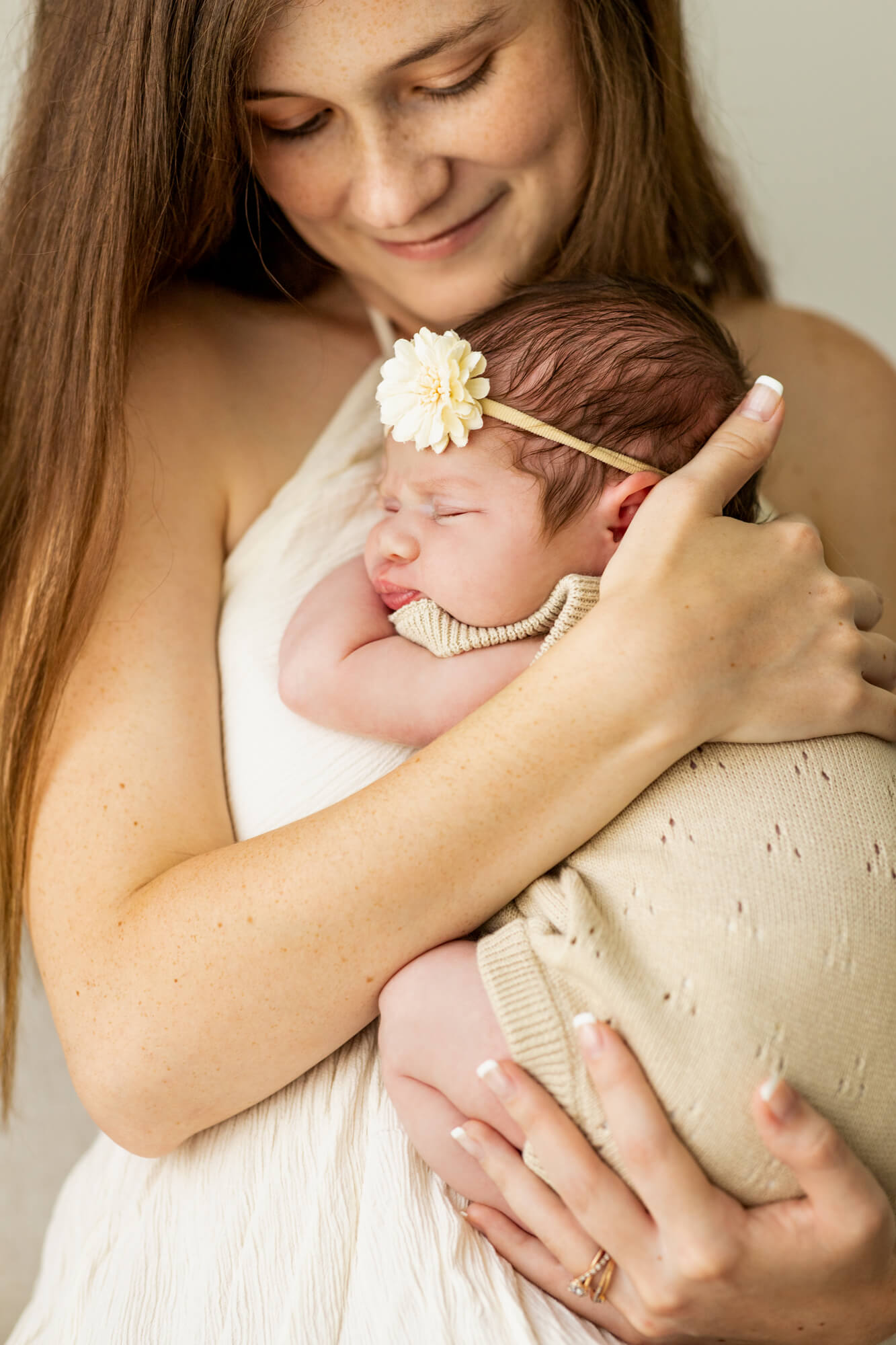 new mom snuggling her baby girl wrapped in tan swaddle Birmingham Breastfeeding