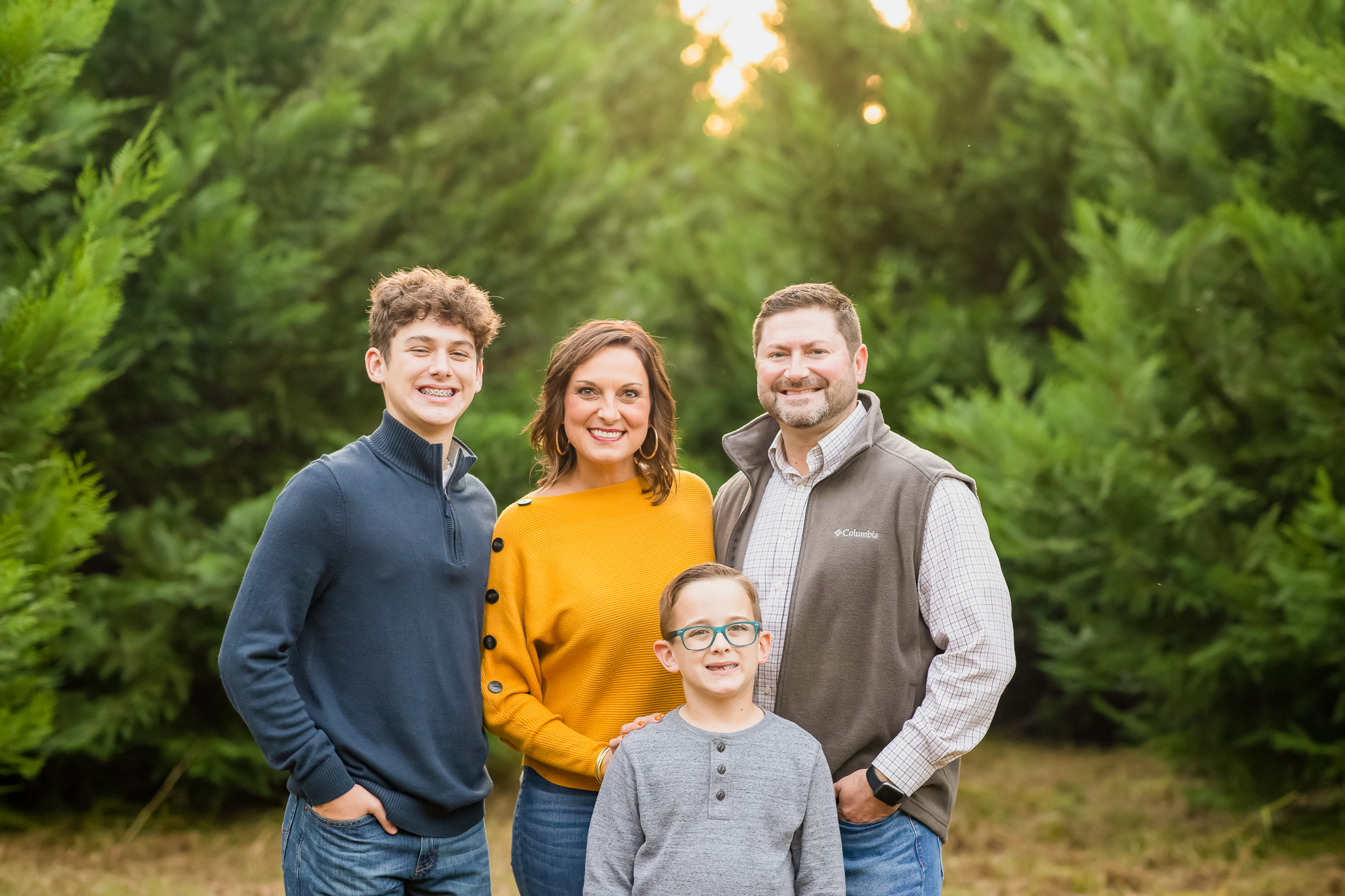 Family of 4 in fall colors at a tree farm