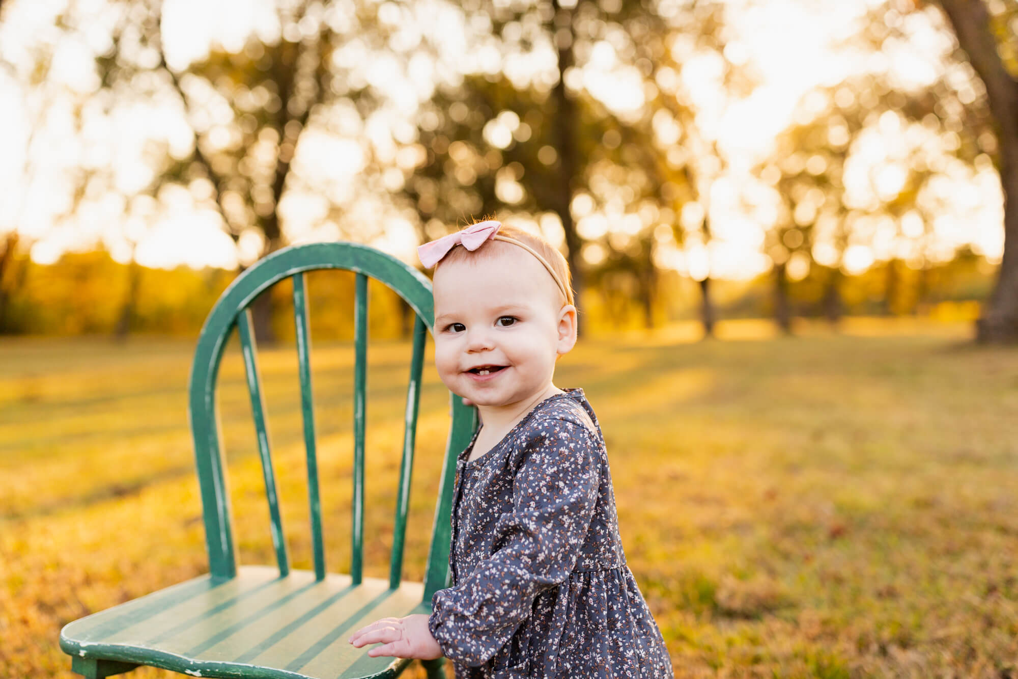 Toddler with two front teeth stands in a patterned dress in a golden field turquoise boutique hoover al